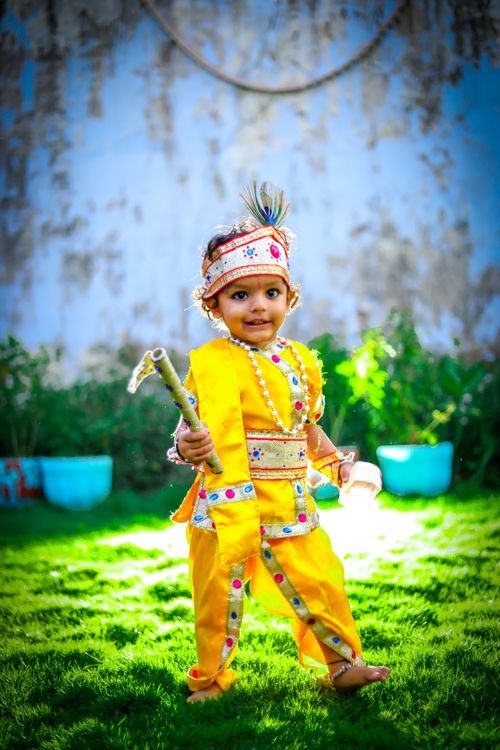 Free Adorable child in colorful traditional Indian attire posing outdoors on a sunny day. Stock Photo