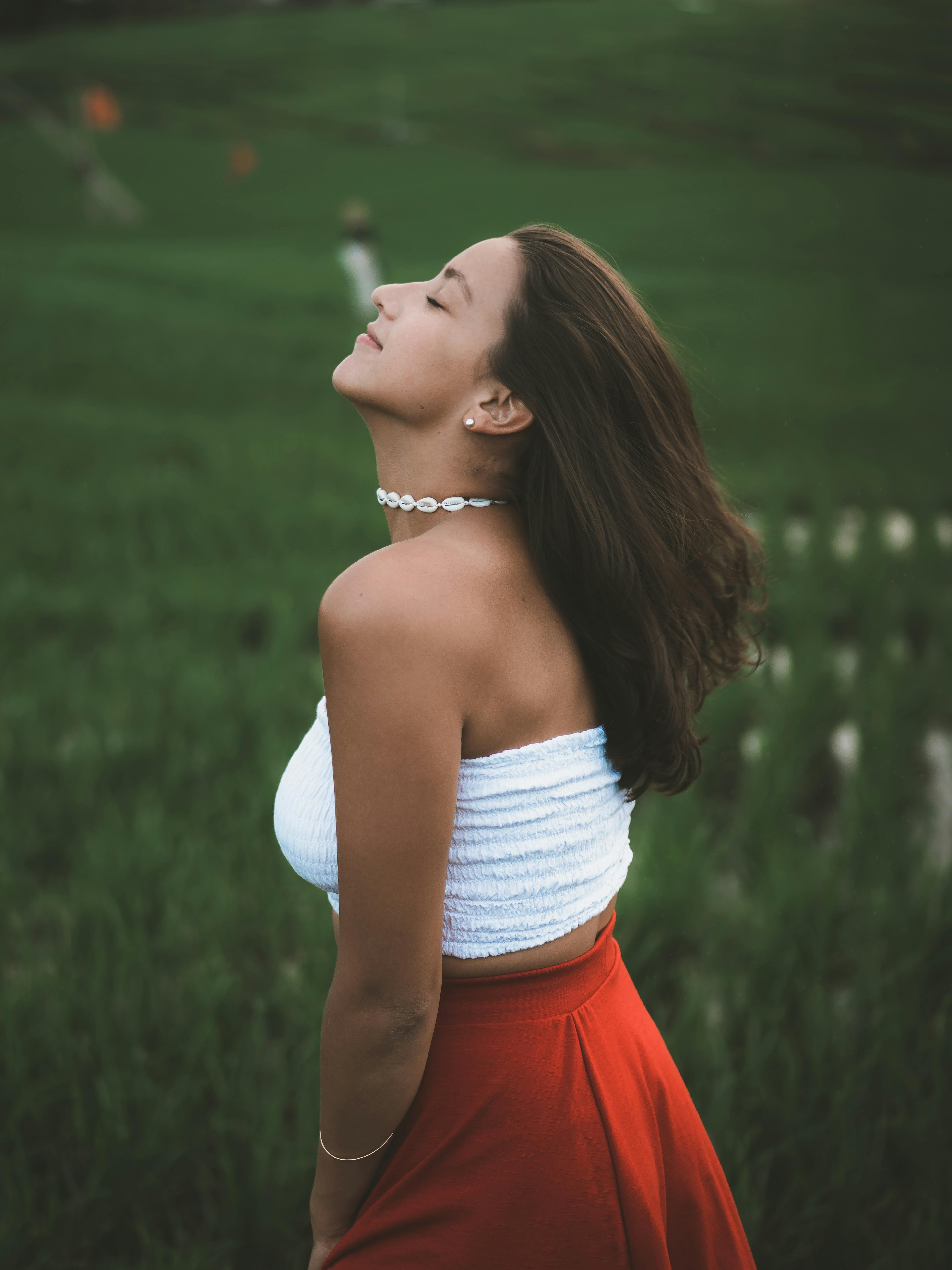 woman wearing white tube top surrounded by green grass