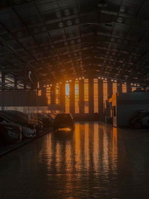 Free Atmospheric sunset casting reflections on a car workshop floor in Samarinda, Indonesia. Stock Photo