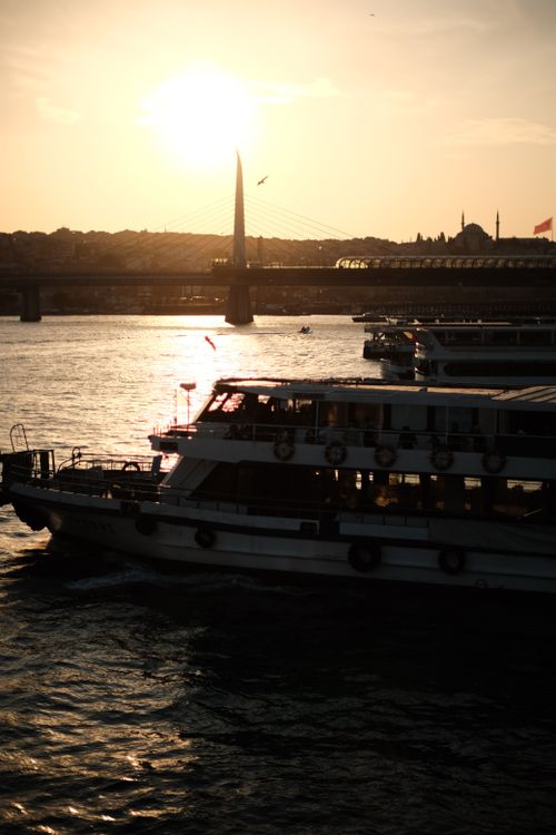 Free Sunset view of boats on Bosphorus with Istanbul skyline and bridge. Stock Photo