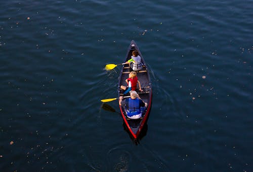 Free People Riding Red Canoe Boat Stock Photo