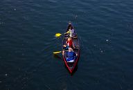 People Riding Red Canoe Boat