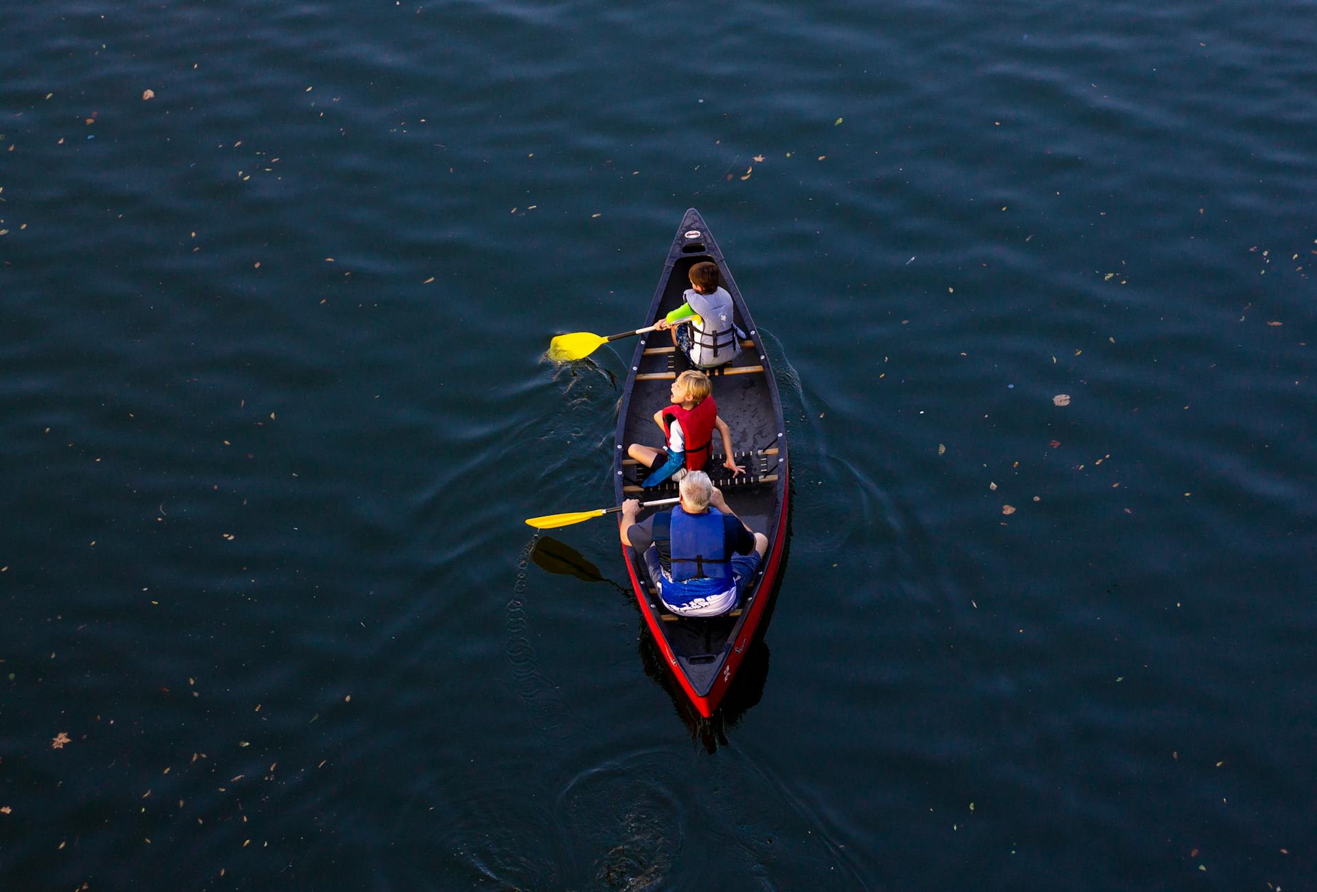 People Riding Red Canoe Boat