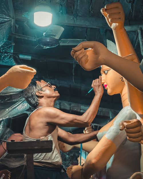 Free Skilled artisan crafting detailed Durga idol in Indian workshop with focus on cultural artistry. Stock Photo