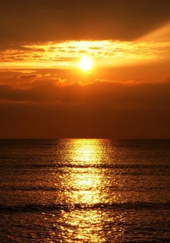A breathtaking view of a golden sunset reflecting on serene ocean waters, evoking tranquility and beauty.