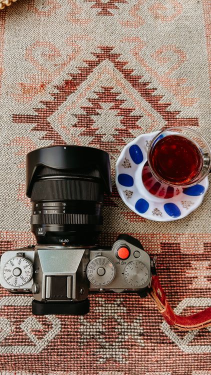 Camera and Tea on Patterned Rug · Free Stock Photo