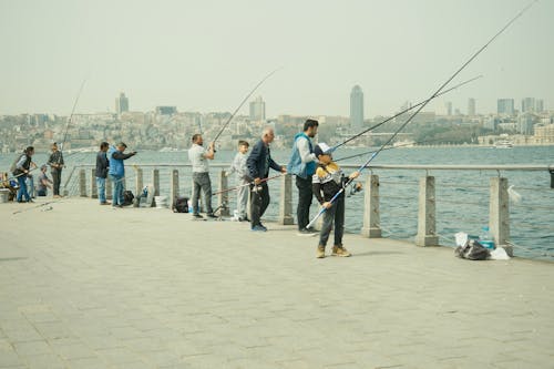 Free Group of people fishing along the waterfront in Üsküdar, Istanbul with cityscape in the background. Stock Photo