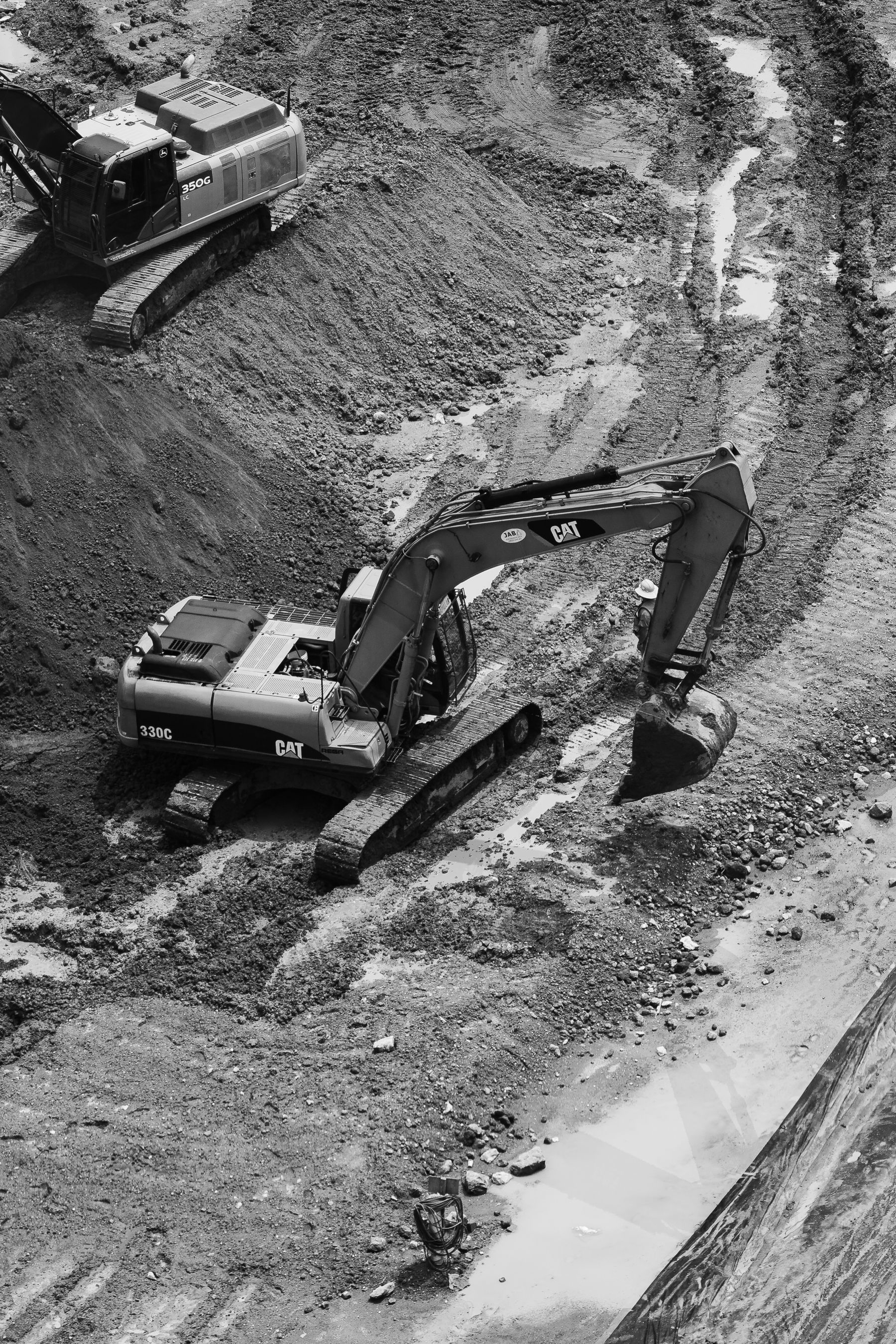 Black and white image of excavators working at a construction site in Ciudad de México, showcasing industrial activity.