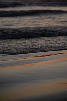 Experience the tranquil beauty of Grover Beach as gentle waves reflect the warm colors of sunset.