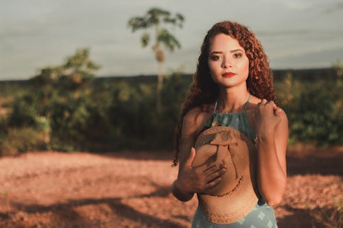 Selectieve Aandacht Foto Van Vrouw In Groene Jurk Poseren Terwijl Zonnehoed Tegen Haar Borst