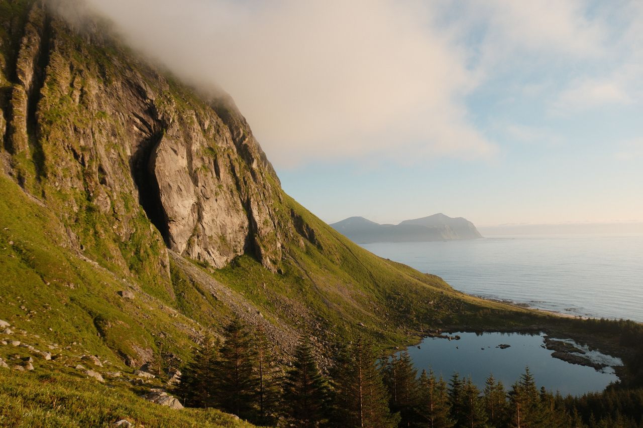 a tranquil alpine scene with towering cliffs a serene lake and the oce