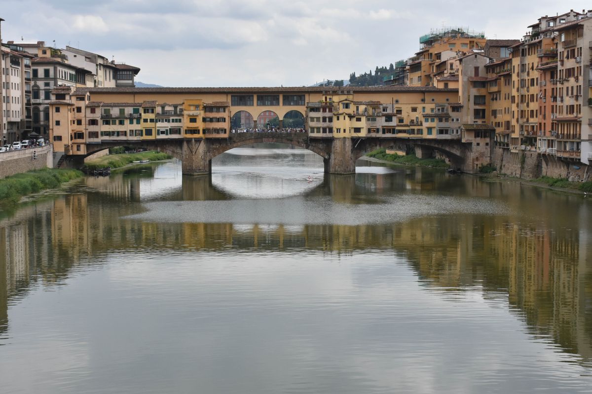 Ponte Vecchio jewelry shops gold ornamental displays in stone arched storefronts Florence Italy
