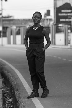Monochrome photo of a woman standing confidently on a city street.
