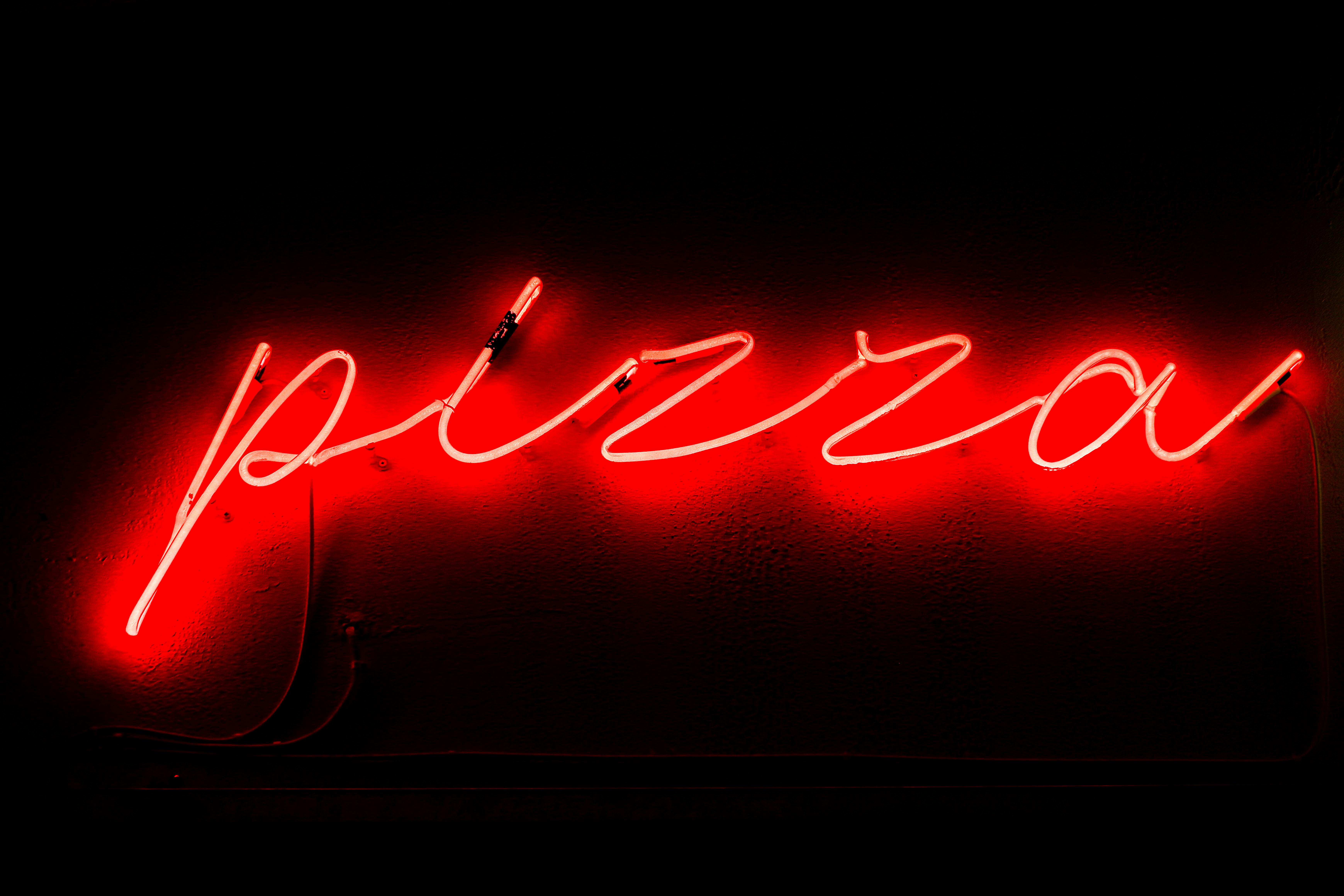 vivid red neon pizza sign in athens