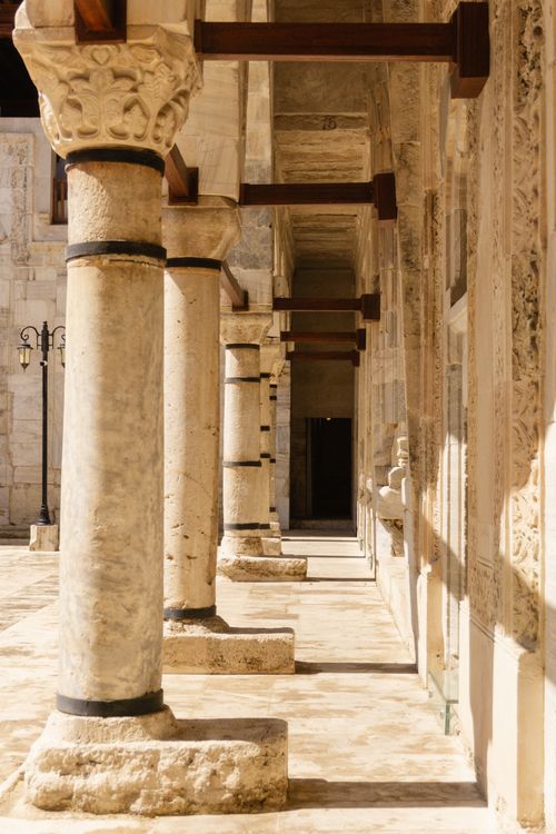 Free A serene view of historic stone columns basking in warm sunlight, showcasing architectural beauty. Stock Photo