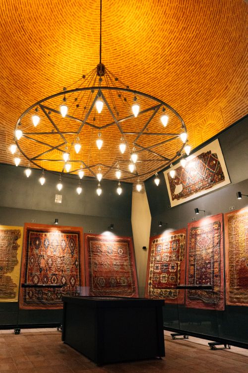 Free Beautiful museum room with traditional rugs and stunning chandelier lighting. Stock Photo