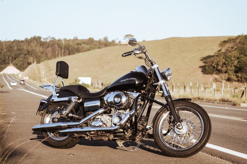 Vintage black motorcycle parked on a scenic open road during a sunny day