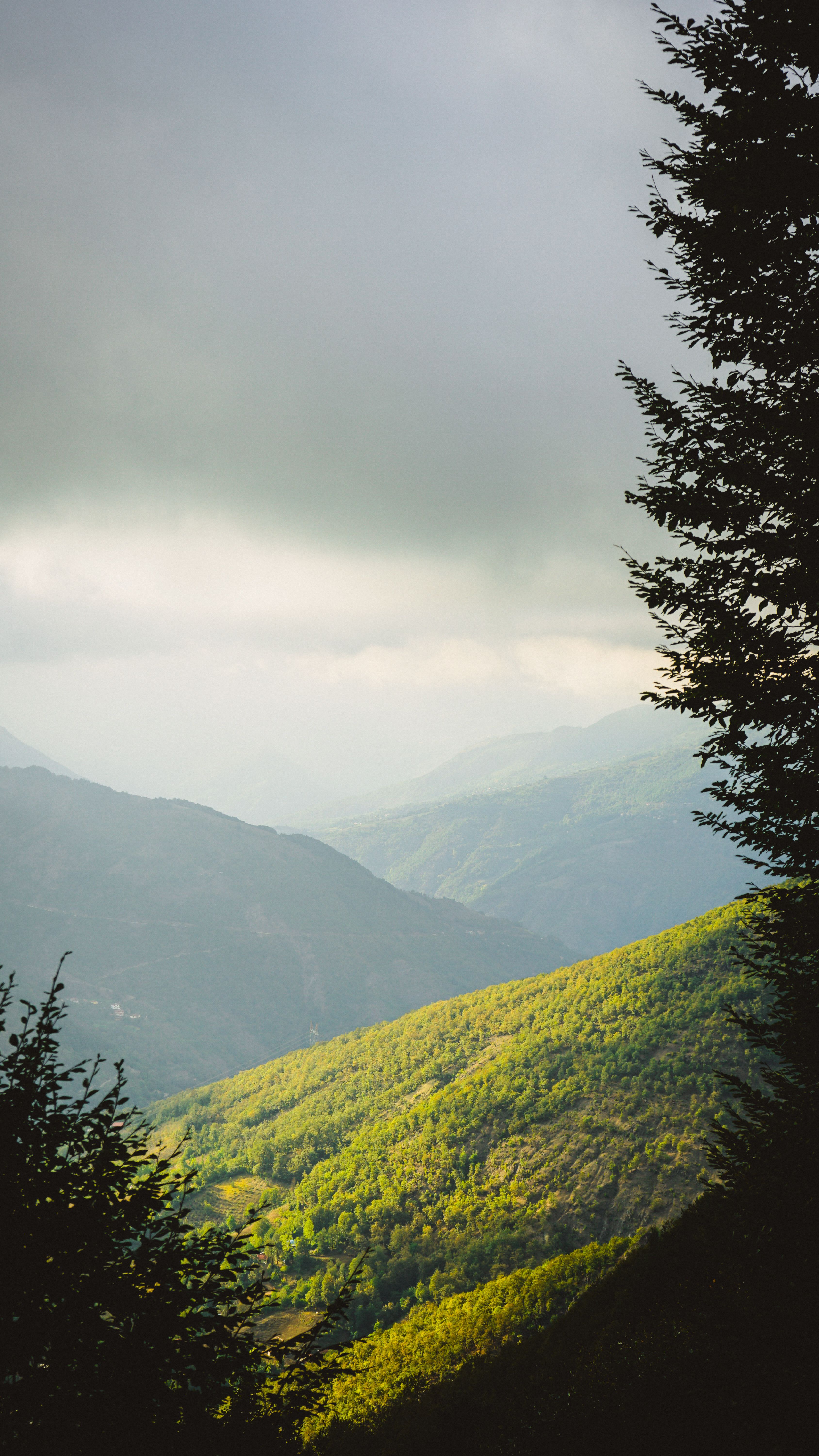 A breathtaking view of the green hills in Erbaa, Tokat, Türkiye under a dramatic sky.