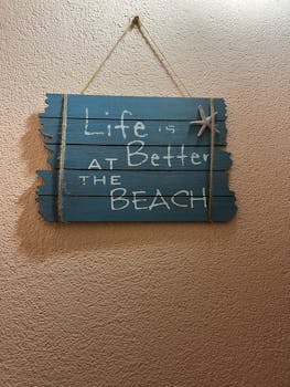 Wooden sign with 'Life is Better at the Beach' message, perfect for coastal decor.