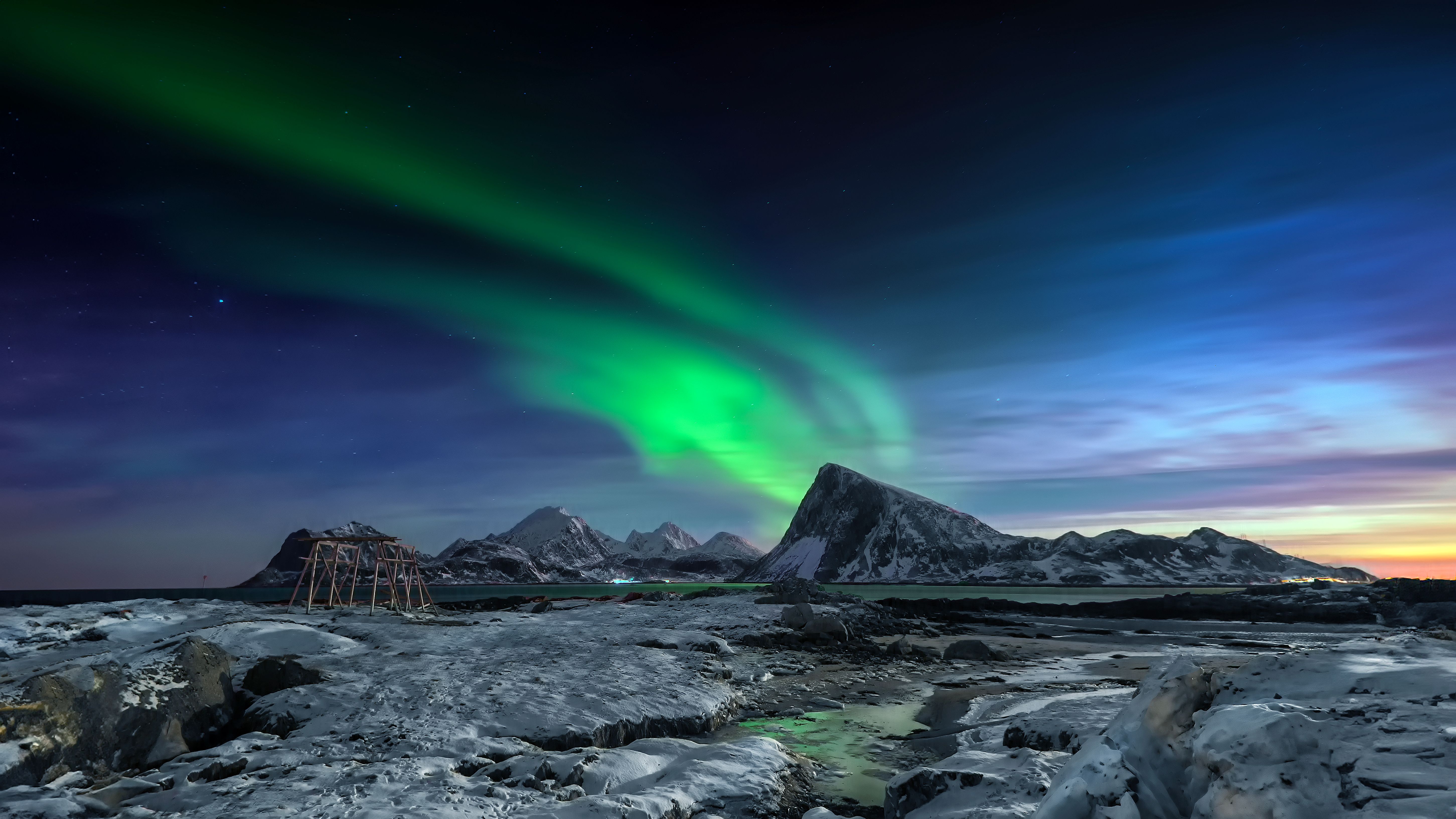 Stunning aurora borealis dancing over snow-covered landscapes in Flakstad, Norway.
