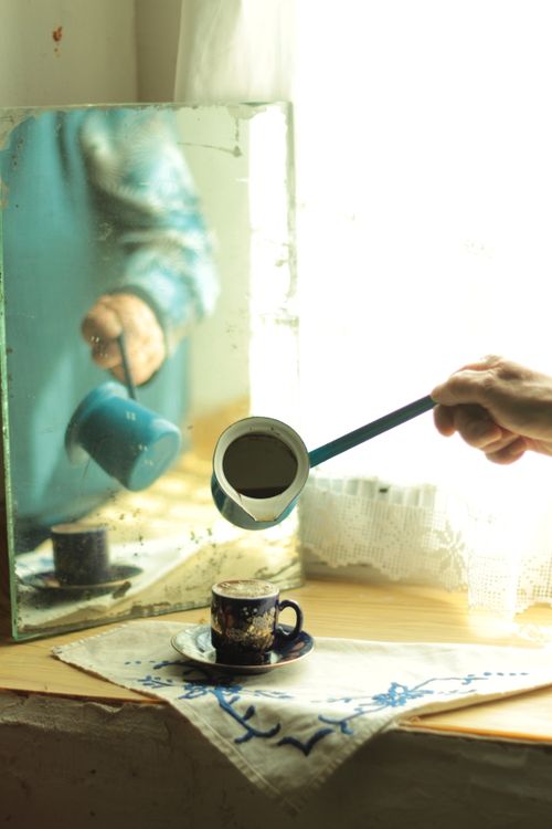 Free Turkish coffee brewing with a cezve, reflecting in a mirror near a bright window. Stock Photo