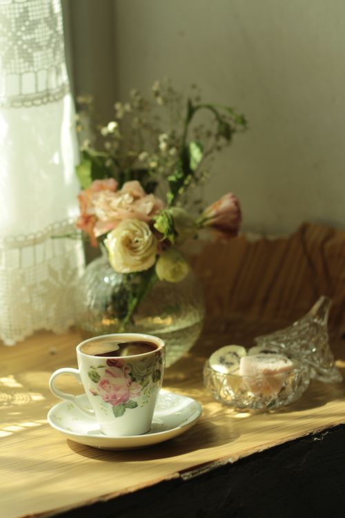 Free Charming Turkish coffee set beside a delicate floral arrangement in soft morning light. Stock Photo