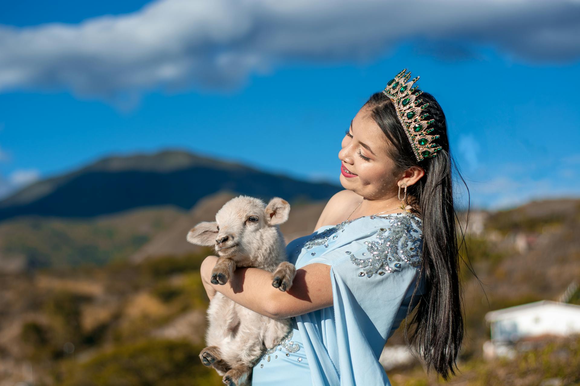 Majestic Woman Holding Lamb in Scenic Mountain View