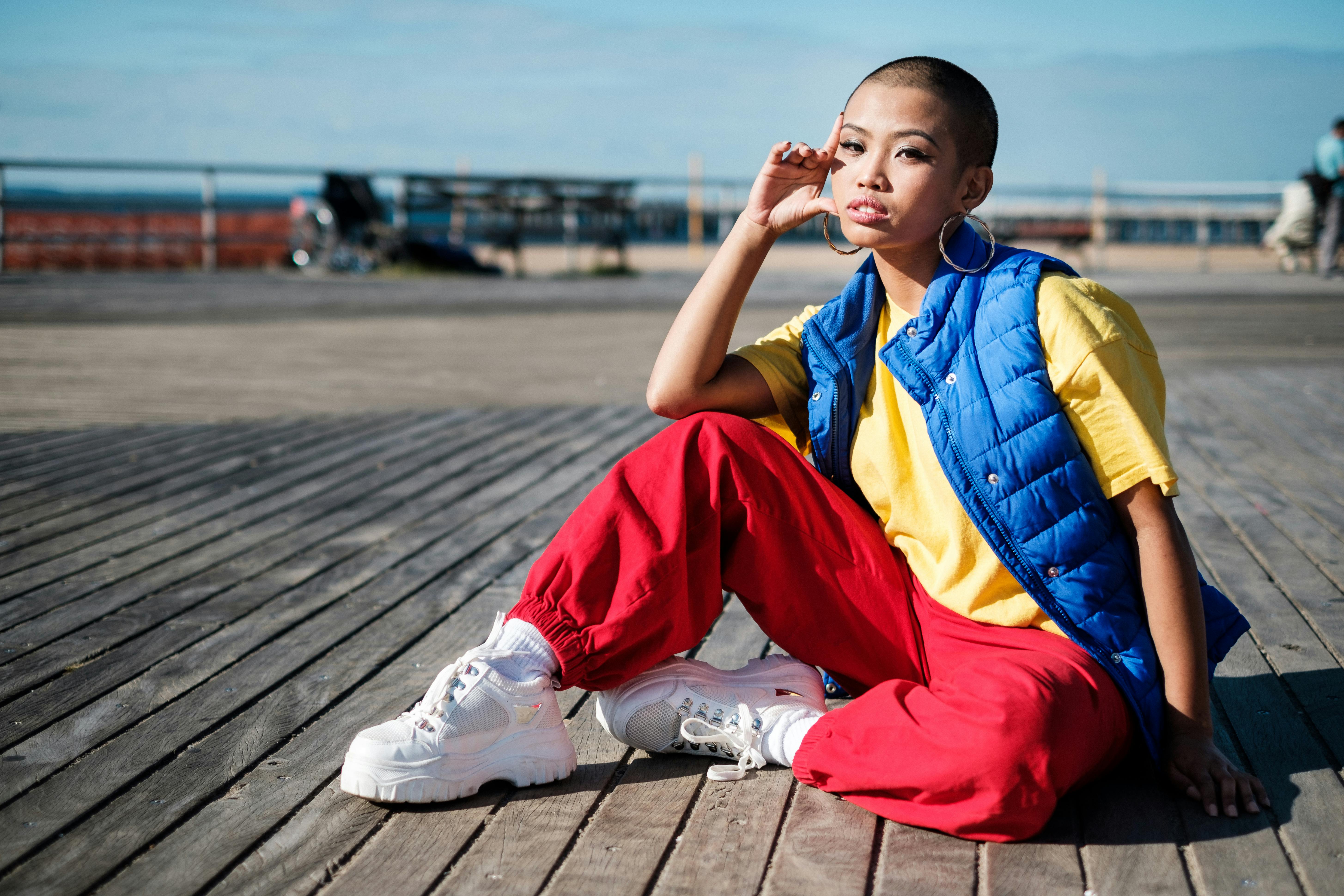 阳光明媚的日子里，一位时尚的亚洲女性穿着休闲装在海边摆姿势