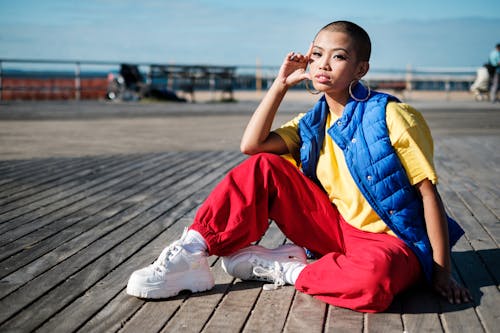 Selective Focus Photo of Woman Sitting on Wooden Floor Posing