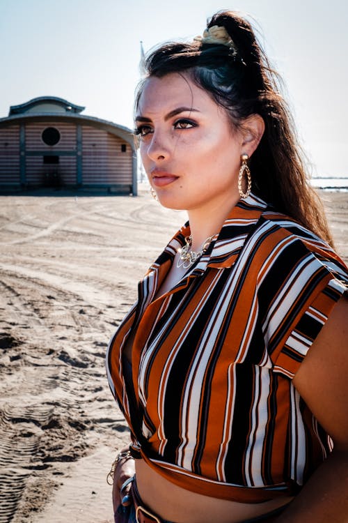Close-up Portrait Photo of Woman Standing on the Beach Posing While Looking Away