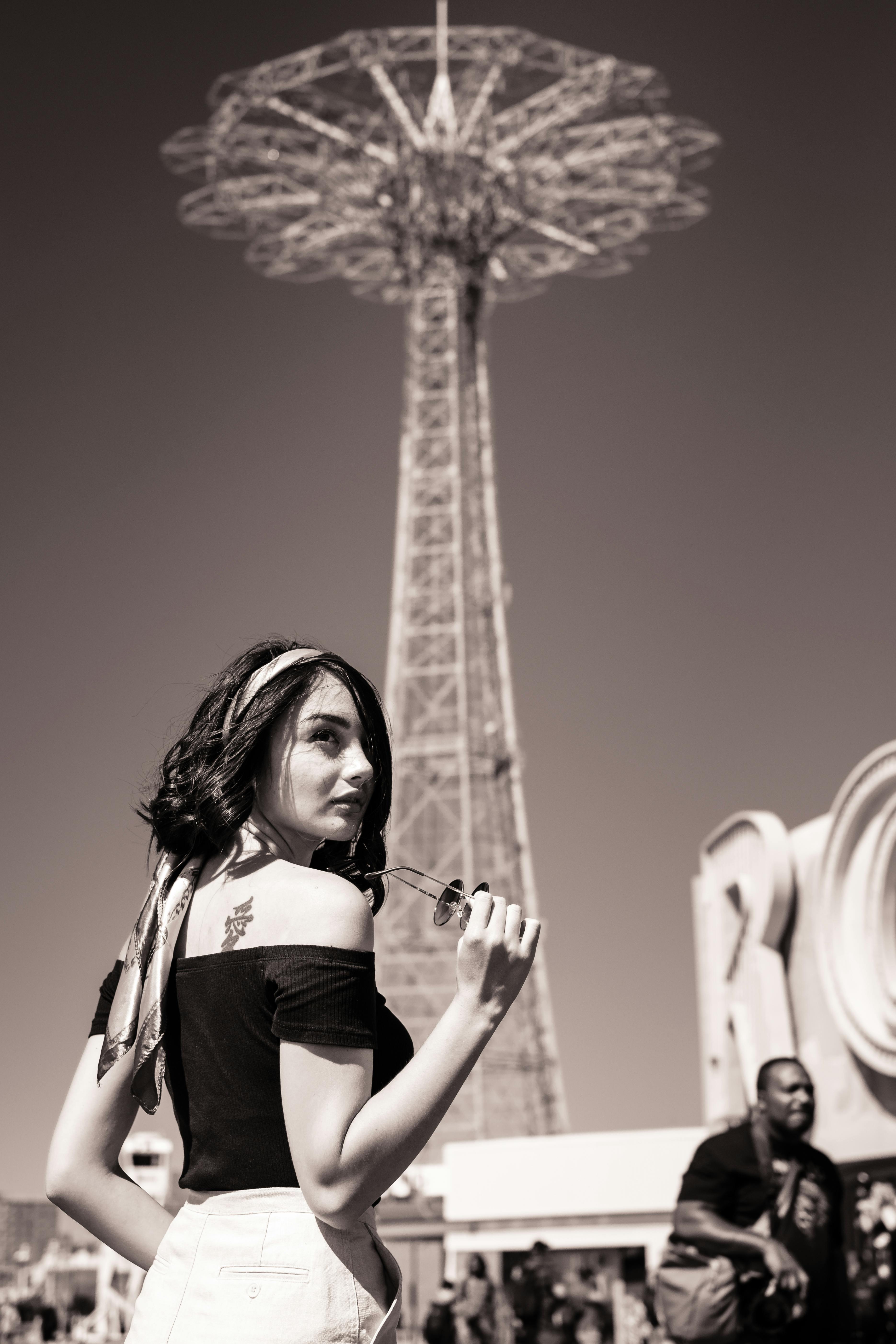 Portrait of a fashionable woman posing in front of Coney Island's Parachute Jump.