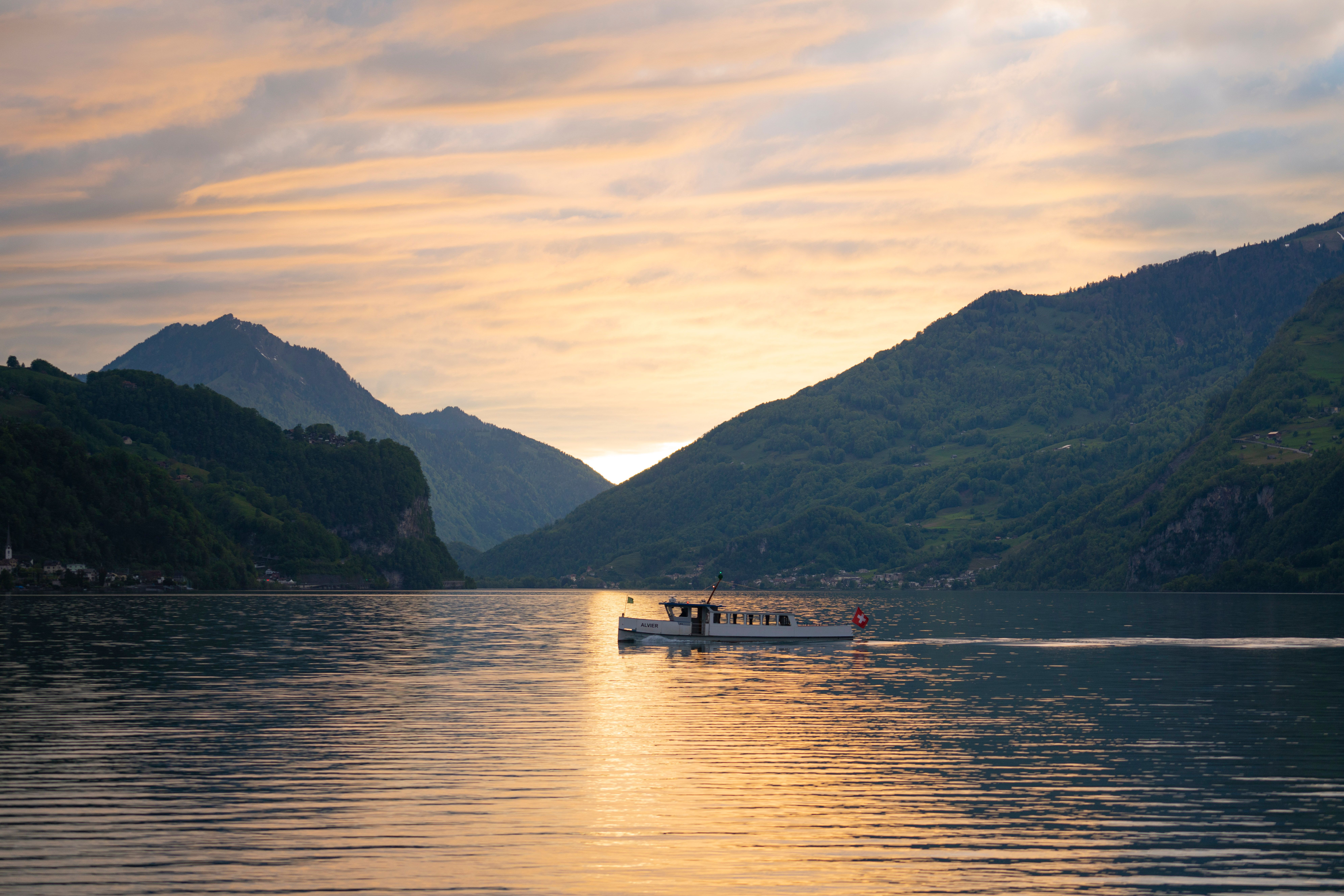 Tranquil Boat Sailing at Sunset on Scenic Lake · Free Stock Photo