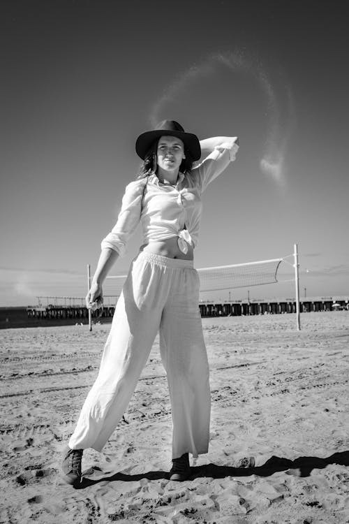 Grayscale Photo of Woman Posing on Sandy Beach