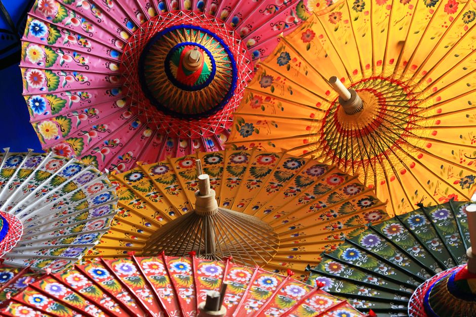 Vibrant top view of traditional Asian paper umbrellas with intricate floral designs.