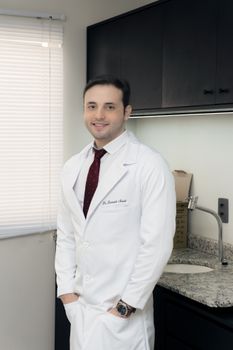 Professional doctor standing confidently in a modern office, embodying healthcare excellence.
