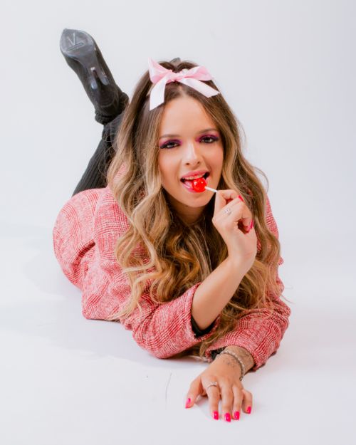 Free Playful adult woman with long hair and lollipop in casual pose. Stock Photo