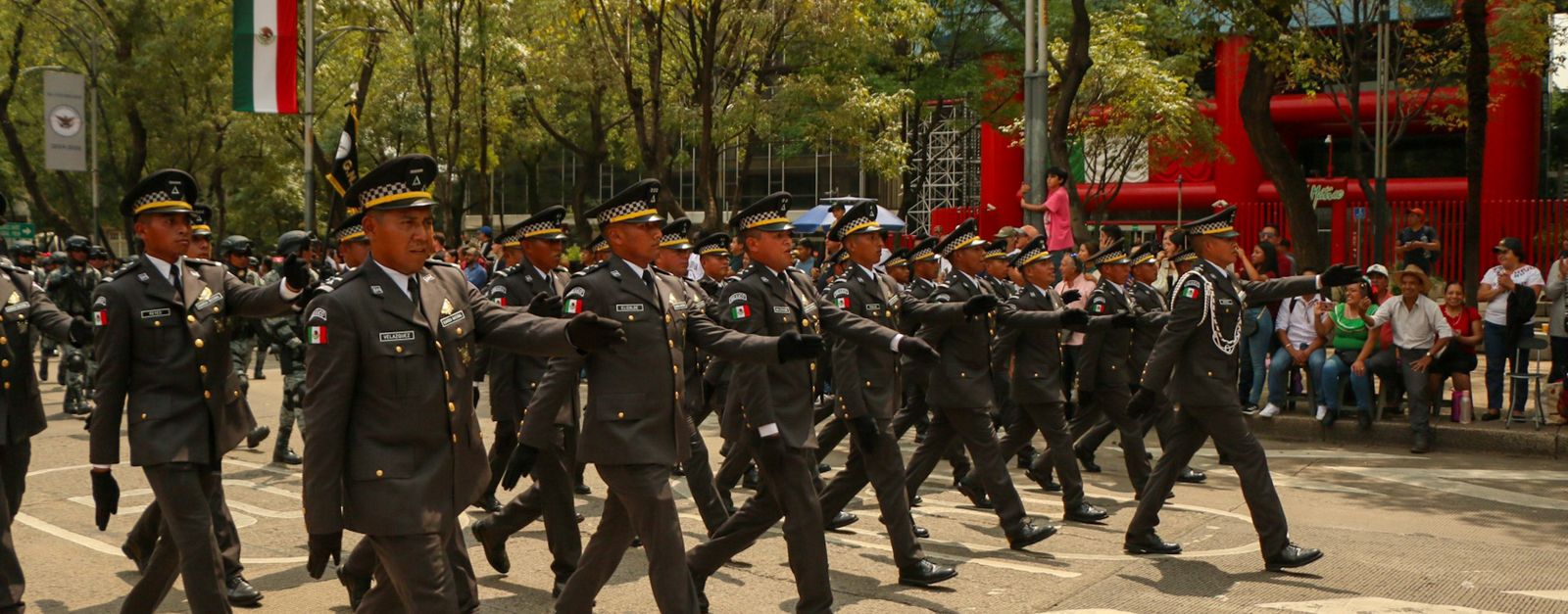 Mexican soldiers in uniform march in a military parade, showcasing discipline and pride.