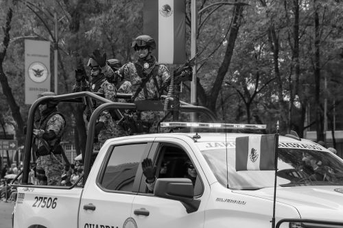 Free Black and white image of soldiers on an armored vehicle during a parade, with flags displayed. Stock Photo