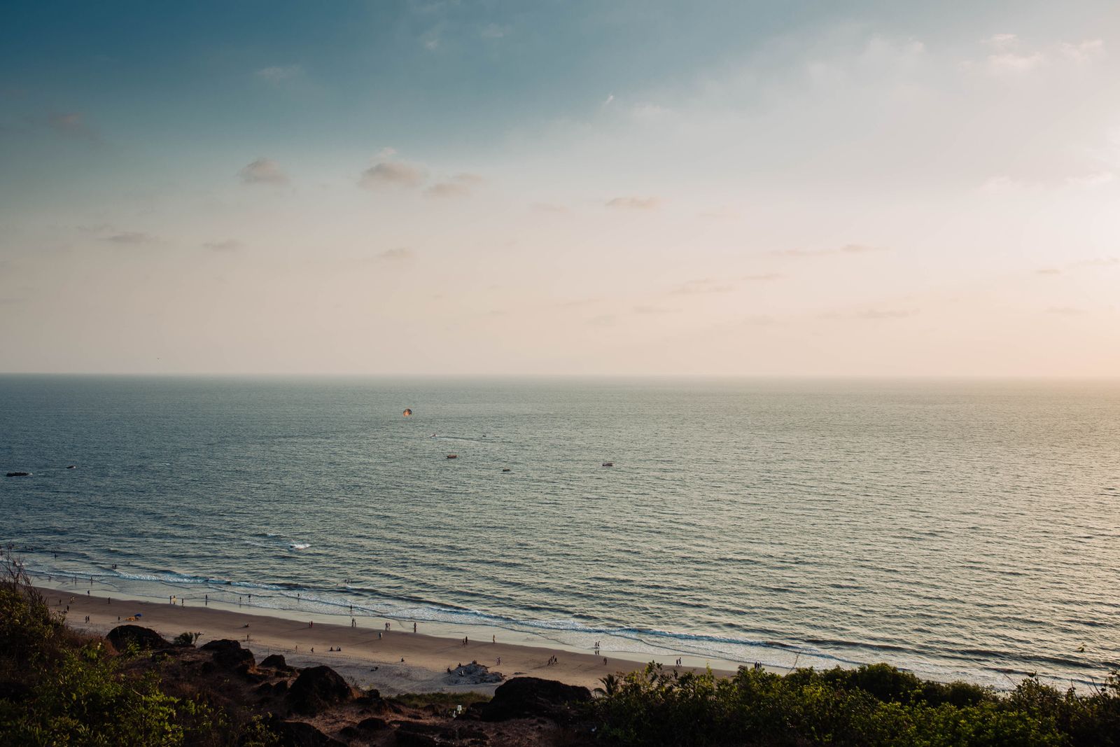 A tranquil view of Chapora Beach in Goa, India captured during sunset with gentle waves and a serene sky.