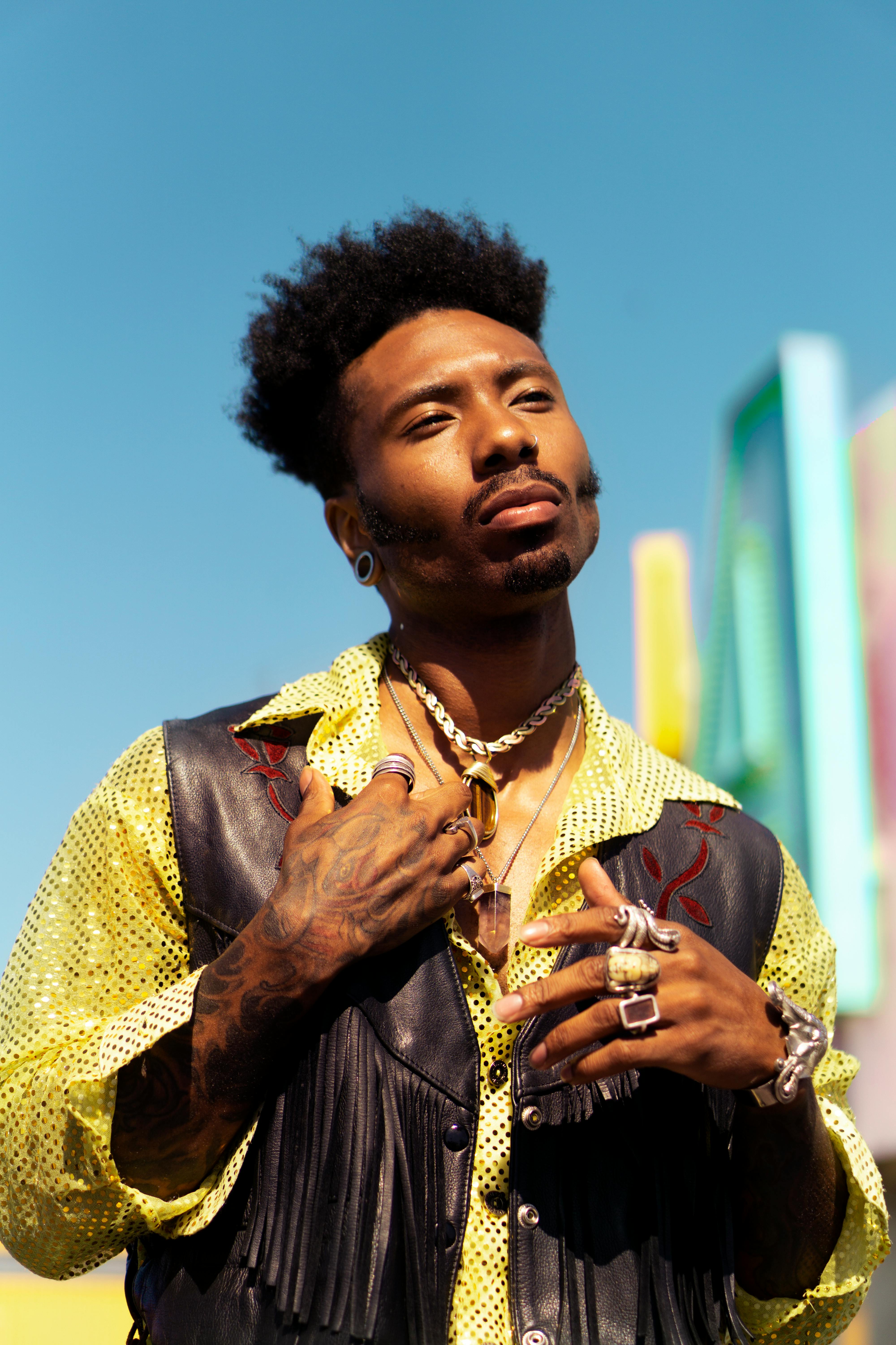 英俊的男人在阳光下展示着独特的时尚与配饰