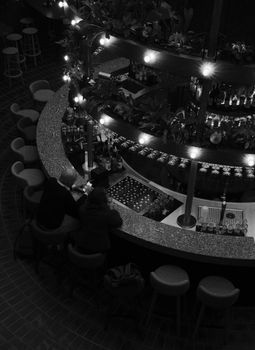 A dimly lit bar with patrons enjoying drinks, creating a warm and inviting atmosphere.