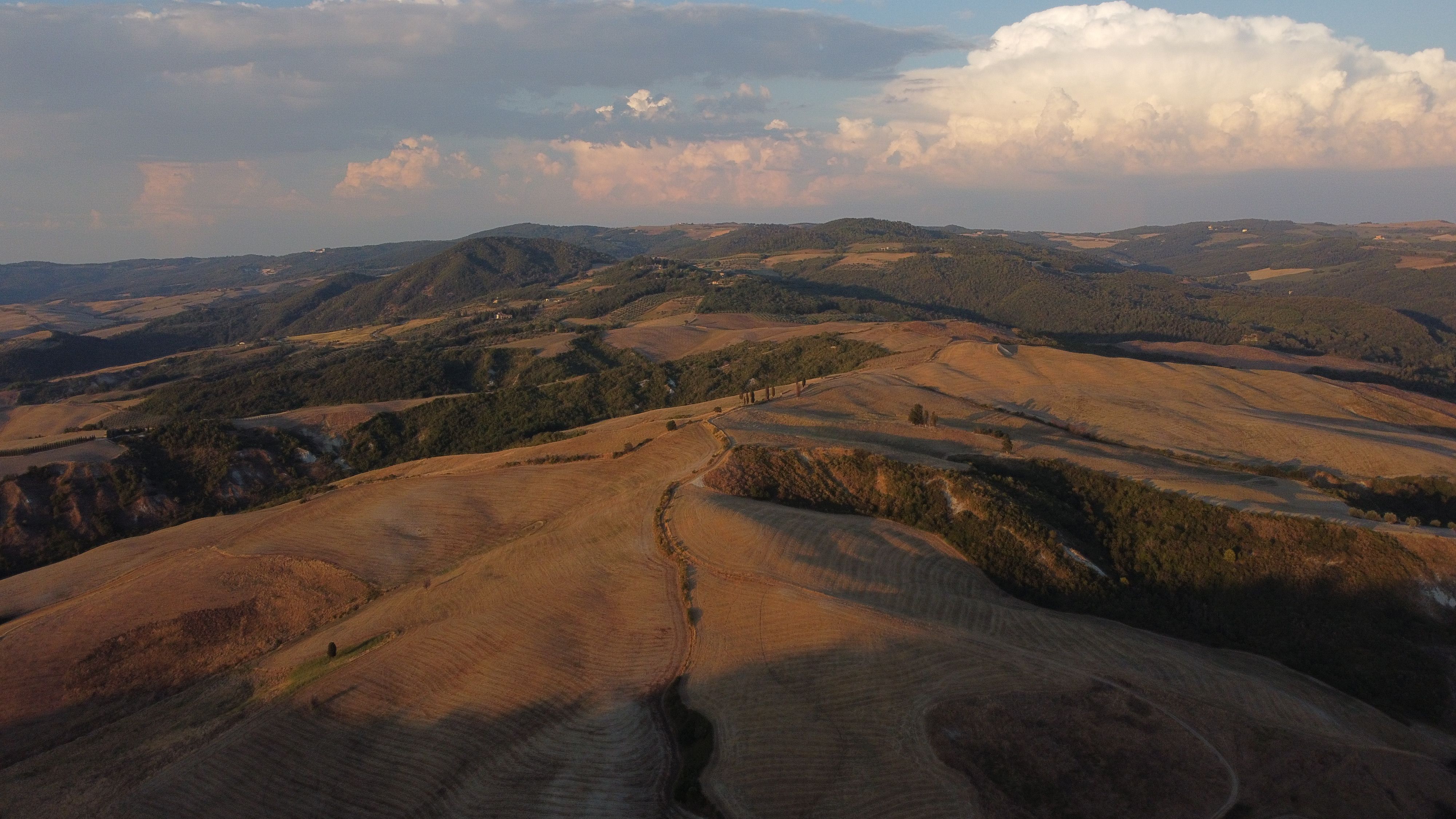 A breathtaking aerial view of the rolling hills in Tuscany during sunset.