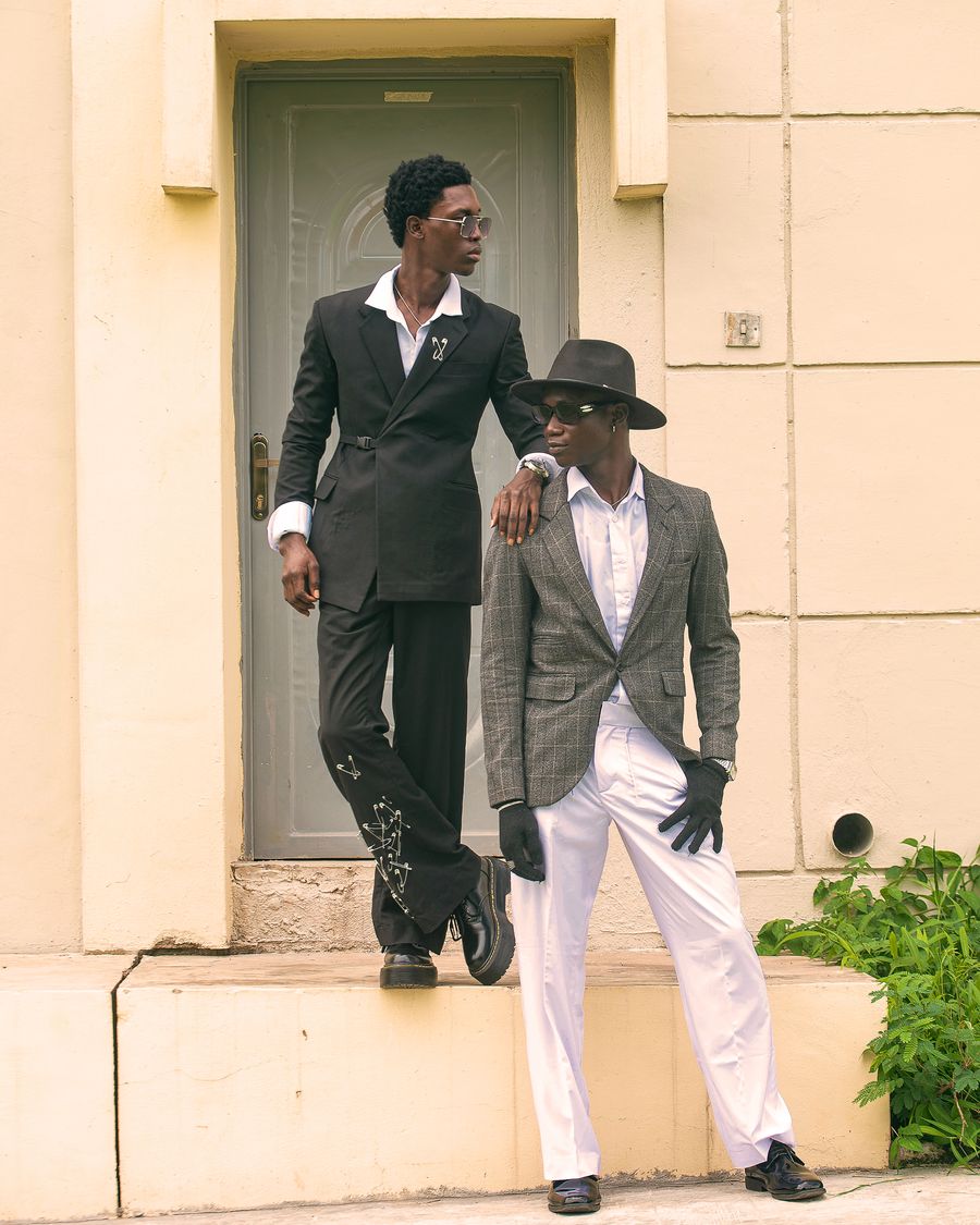 Two men in dark polished outfits outdoors