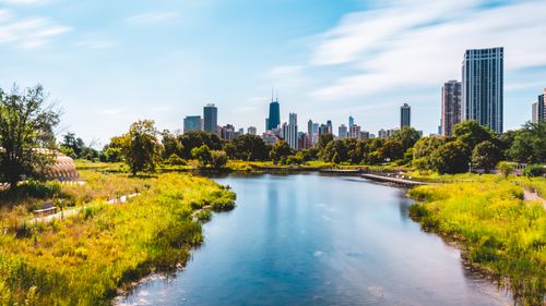 Free Stunning view of Chicago skyline featuring Hancock Tower with adjacent park and river. Stock Photo