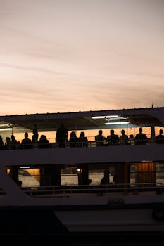 Silhouettes of people on a ferry during a sunset, capturing the vibrant skyline of Istanbul.