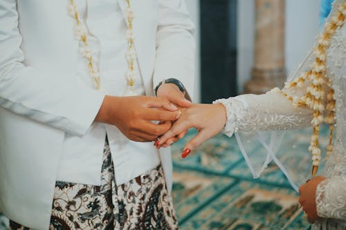 Free Man Putting a Gold-colored Ring to a Woman's Hand Stock Photo
