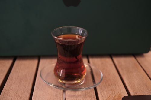 Free Traditional Turkish tea in tulip glass on a wooden table in Bornova, Izmir. Stock Photo
