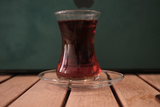 Experience authentic Turkish tea served in a traditional glass on a wooden table.