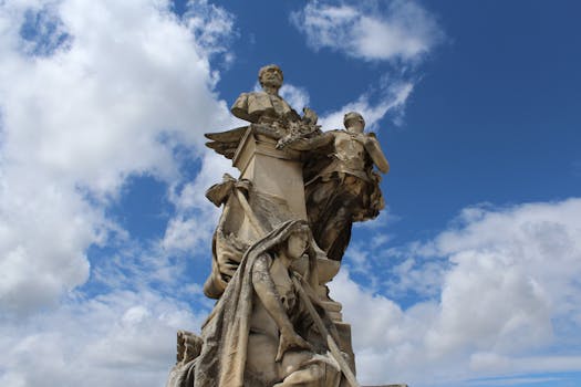 A stunning statue set against a vibrant blue sky with clouds in Angoulême, France.