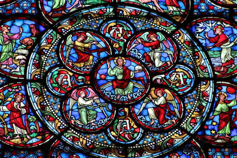 Vibrant stained glass window depicting biblical scenes and figures in a church.